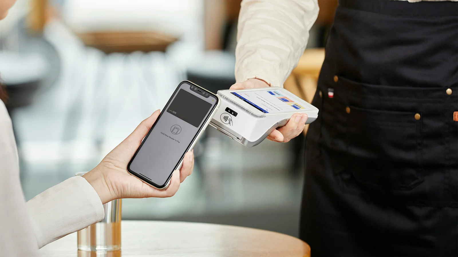 Customer tapping a phone to pay on a POS terminal